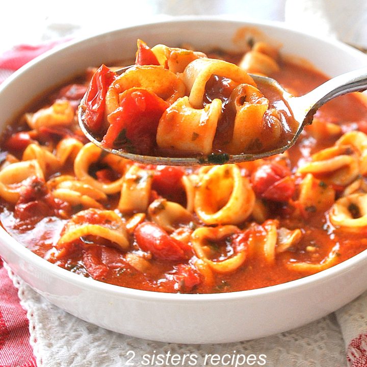 A spoonful of calamari rings smothered in a tomato broth.