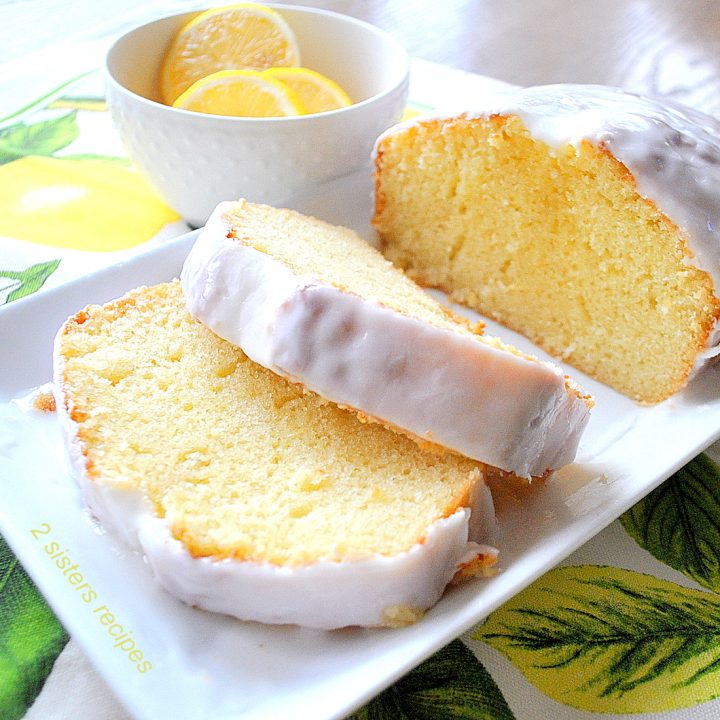 Slices of lemon pound cake topped with white icing served on a white platter.