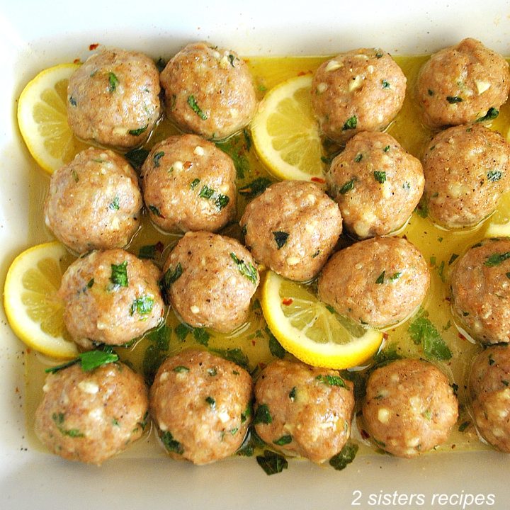 Turkey Meatballs with sliced lemons in a baking dish.