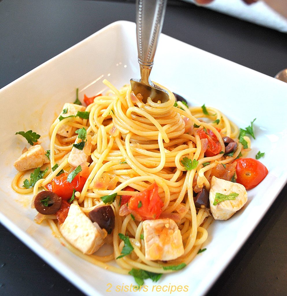 A fork twirled inside the center of the spaghetti in a white square bowl. by 2sistersrecipes.com