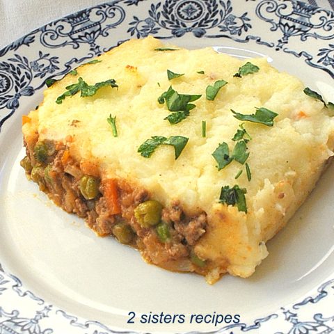 served on a white and blue plate is an Easy Shepherd's Pie Recipe topped with chopped parsley as garnish.