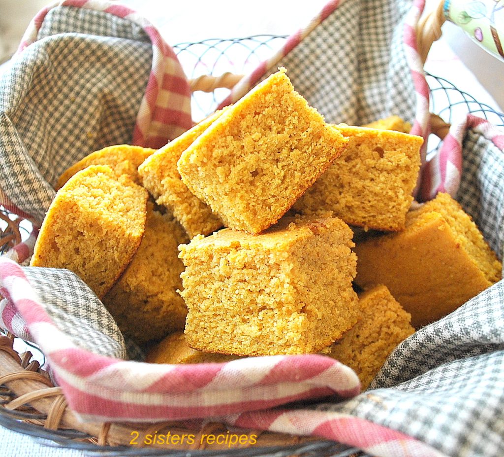 A basket filled with pieces of pumpkin cornbread.