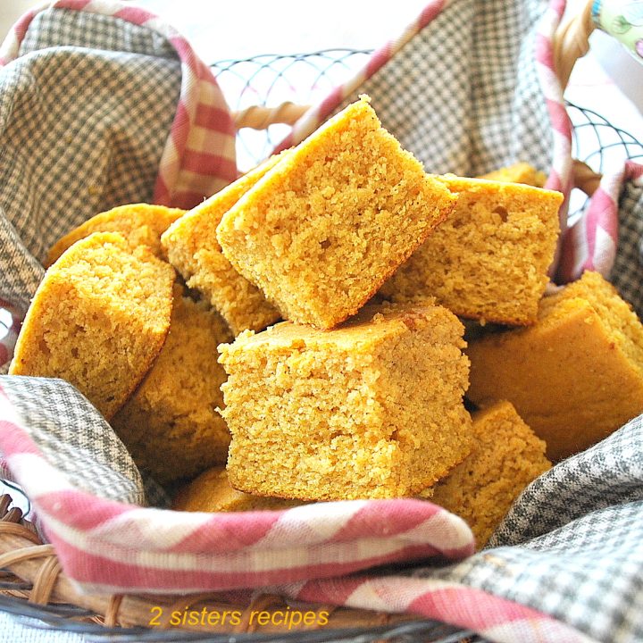 A basket filled with pieces of pumpkin cornbread.