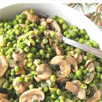A white bowl filled with sautéed peas and mushrooms.