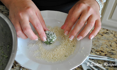 one spinach ball rolled in panko bread crumbs in a white dish. by 2sistersrecipes.com