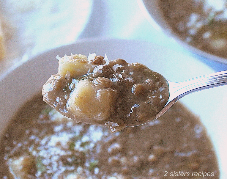 A spoonful of lentil soup with potatoes. by 2sistersrecipes.com