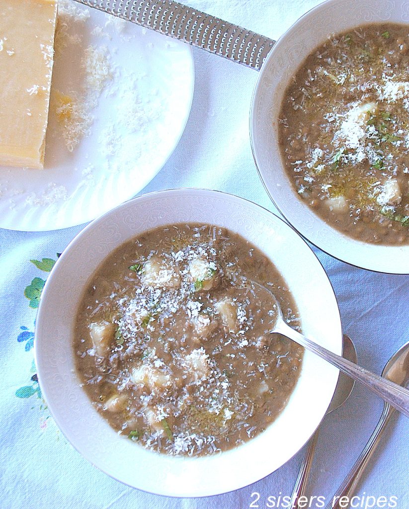 2 small white bowls of soup with a spoon inside one. by 2sistersrecipes.com