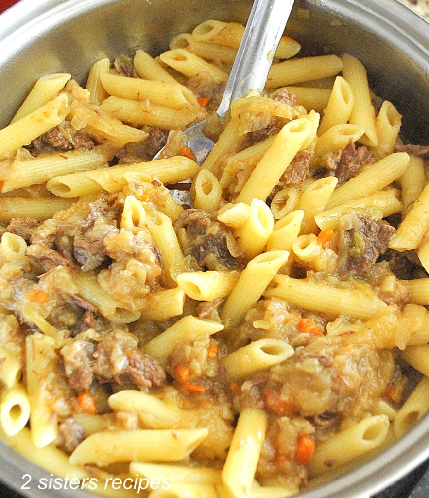 A llarge pot filled with penne pasta tossed with Genovese Sauce. by 2sistersrecipes.com