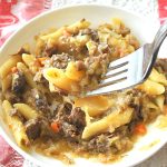 A forkful of pasta with Genovese sauce over a bowl.