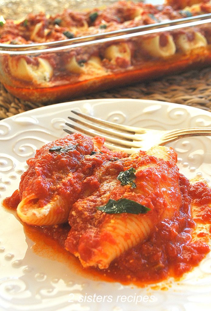 2 pasta shells with tomato sauce on a white serving plate. by 2sistersecipes.com