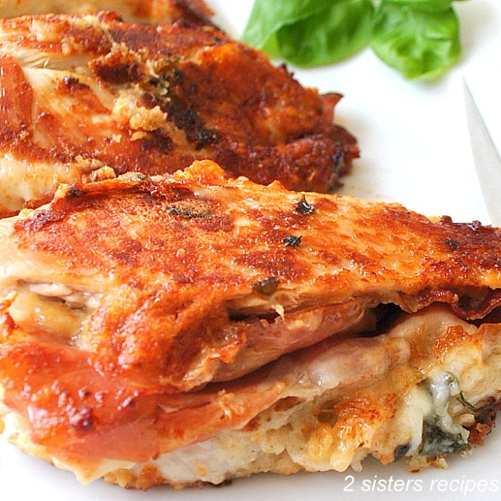 Golden brown chicken breasts stuffed on a white plate.