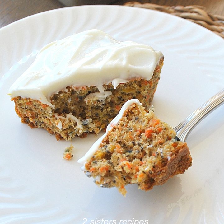 A forkful of carrot cake with frosting on top.