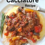 A dinner plate with a bed of polenta, topped with a chicken cacciatore stew with vegetables.