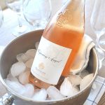 A bottle of Rose' wine in a bucket filled with ice. by 2sistersrecipes.com