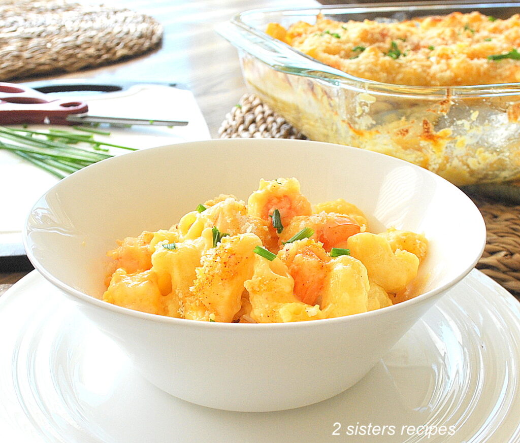 A white bowl filled with a shrimp mac and cheese. 
