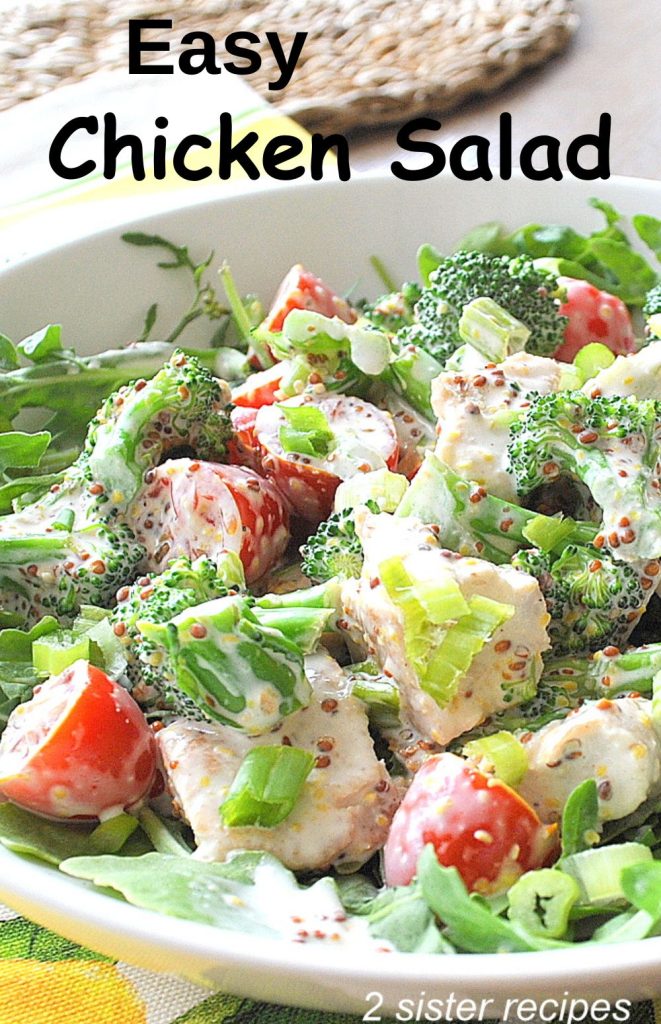 A white bowl filled with lettuce, tomatoes and grilled pieces of chicken.