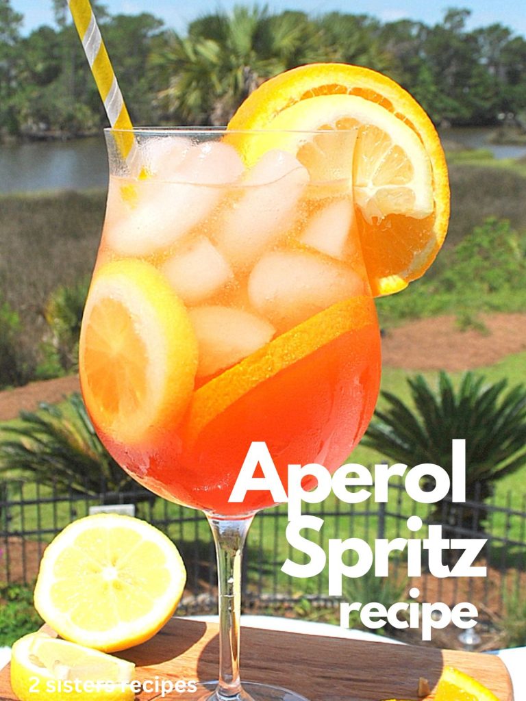 A tall wine glass filled with ice cubes, slices of lemon and orange, Aperol liqueur.   Recipe by 2sistersrecipes.com
