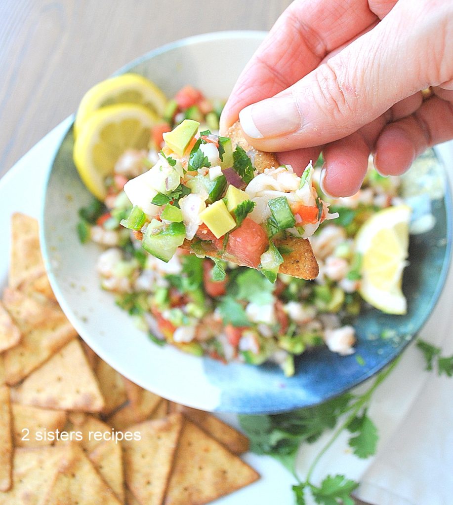 Holding a chip loaded with the shrimp salsa dip. by 2sistersrecipes.com 