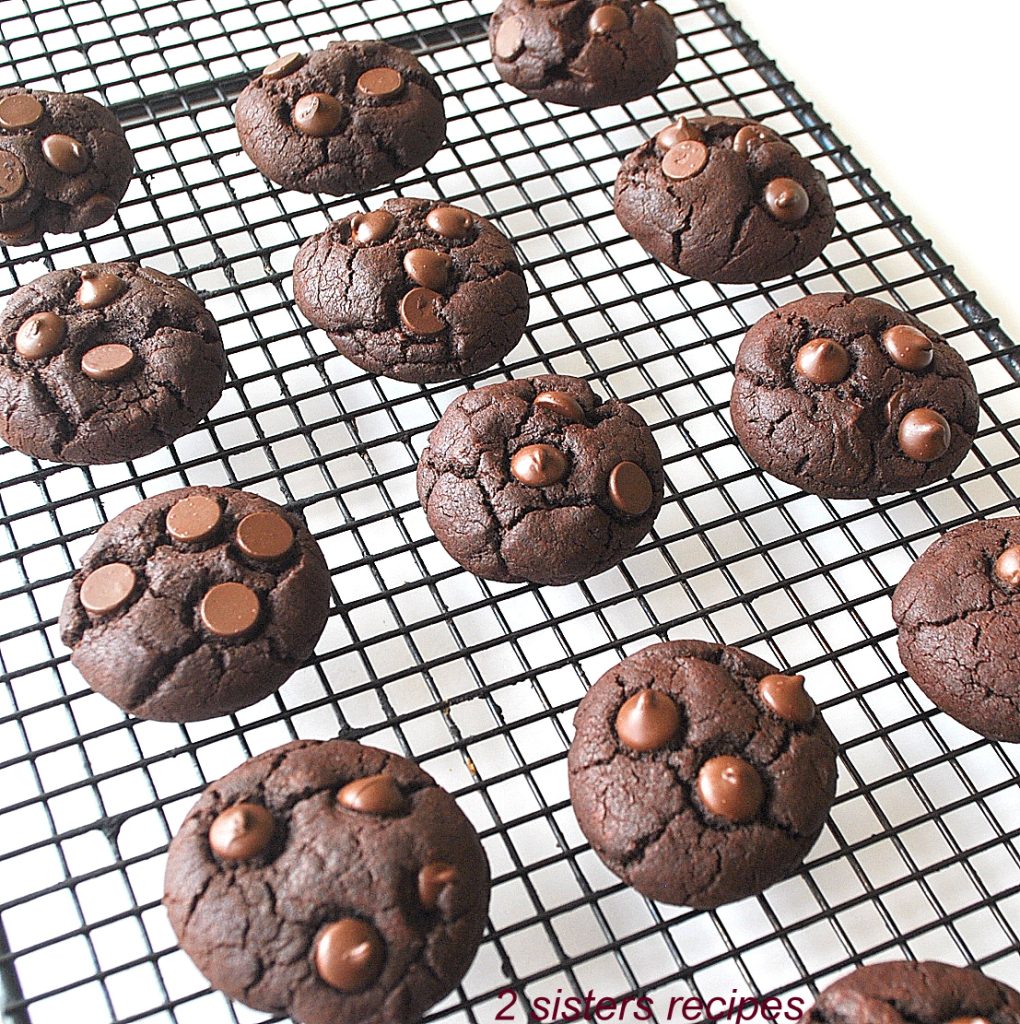 A wire rack with chocolate chip brownie cookies, by 2sistersrecipes.com