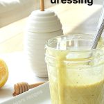 Honey Mustard Dressing in a mason jar, with a white bottle for honey.
