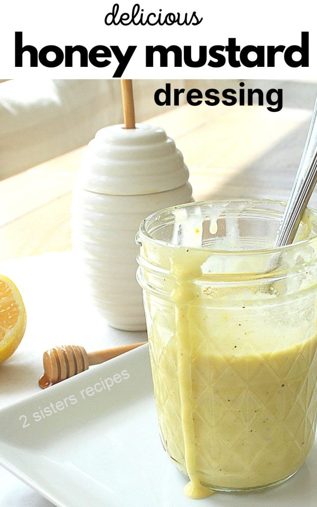 Honey Mustard Dressing  in a mason jar, with a white bottle for honey. 