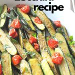 An oval white platter filled with baked baby zucchini and cherry tomatoes.