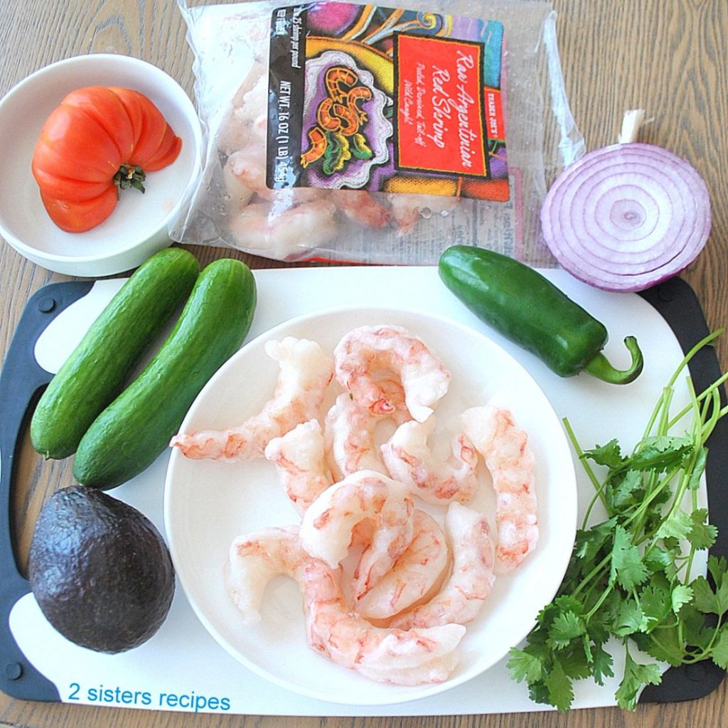All the ingredients for the Shrimp Avocado Salsa are laid on a white board and table. 