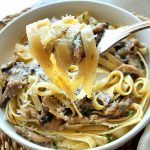 A forkful of fettuccine pasta and mushroom ragu.