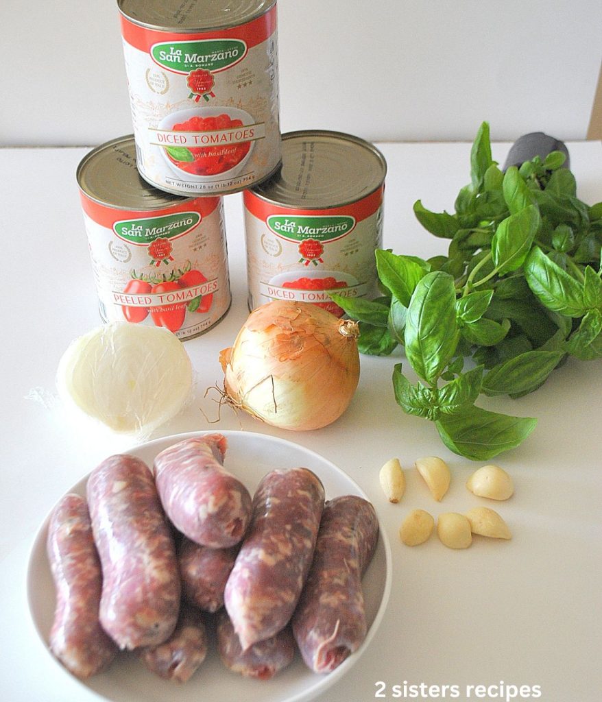 All the ingredients for sausage ragu sitting on a white board.  by 2sistersrecipes.com