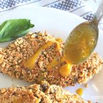 Some honey-mustard sauce is drizzled over baked nut-crusted chicken. by 2sistersrecipes.com