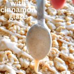 A sheet pan with a pumpkin crumb cake and a spoon with a glaze over the cake.