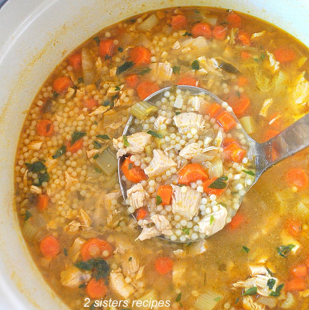 A big pot filled with Homemade Chicken Soup by 2sistersrecipes.com