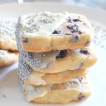 A pile of 4 butter cookies with icing and silver beads.