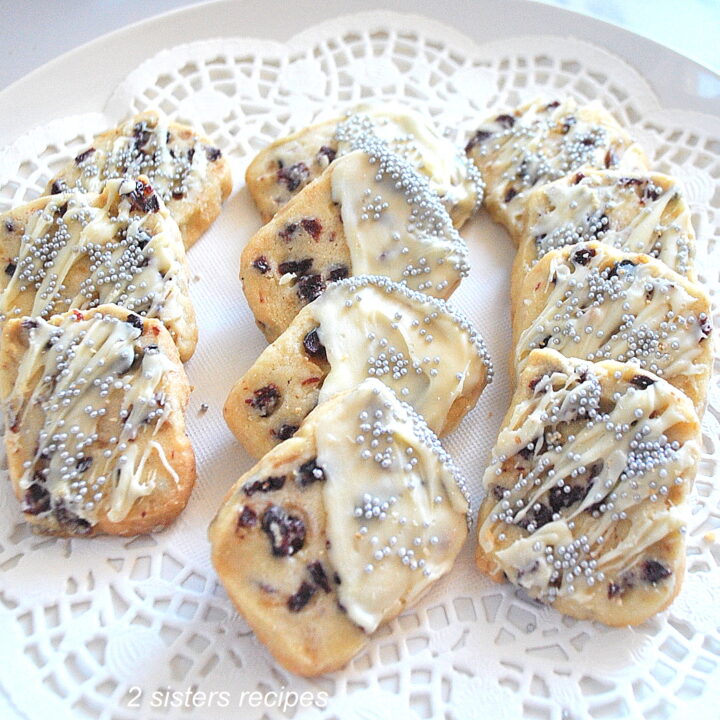 Cranberry butter cookies displayed on a white doily in a plate.