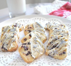A white doily with cranberry speckled shortbread cookies served.