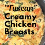 A black skillet filled with chicken breasts in a creamy sauce,
