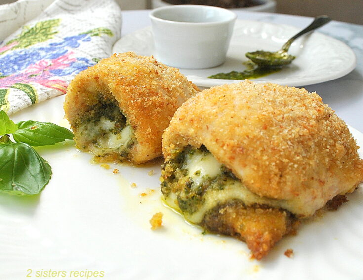 A chicken rollatini's stuffed with pesto and cheese served on a white dinner plate.