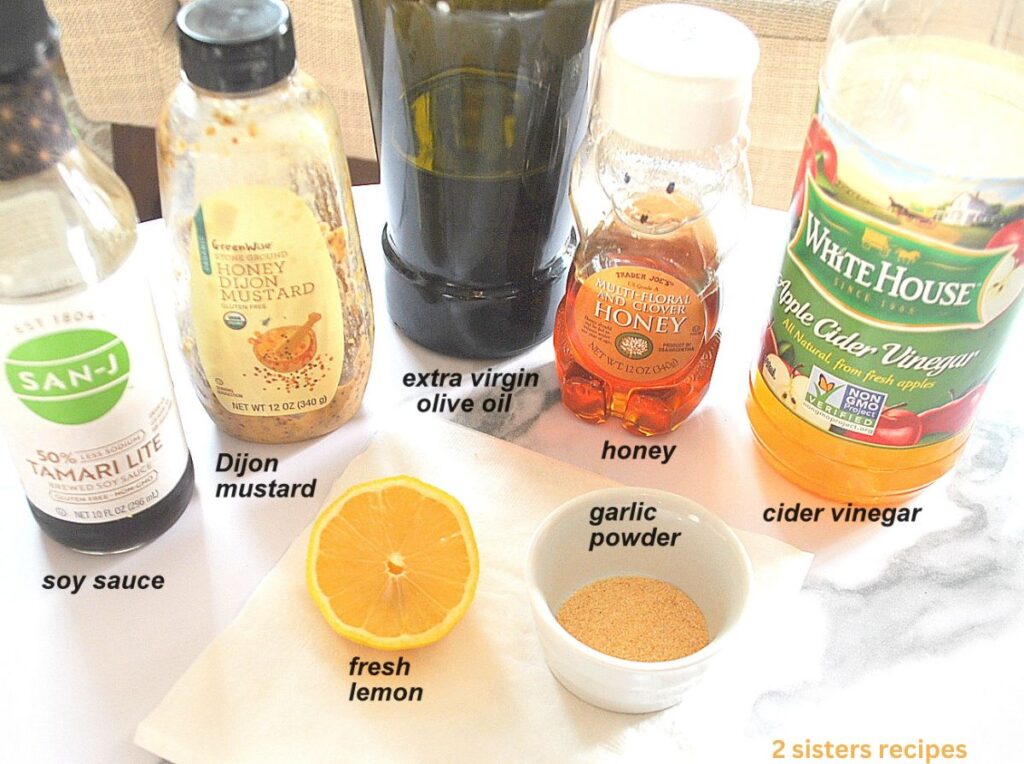 Ingredients to make the Dijon honey vinaigrette are placed on the table and labeled.