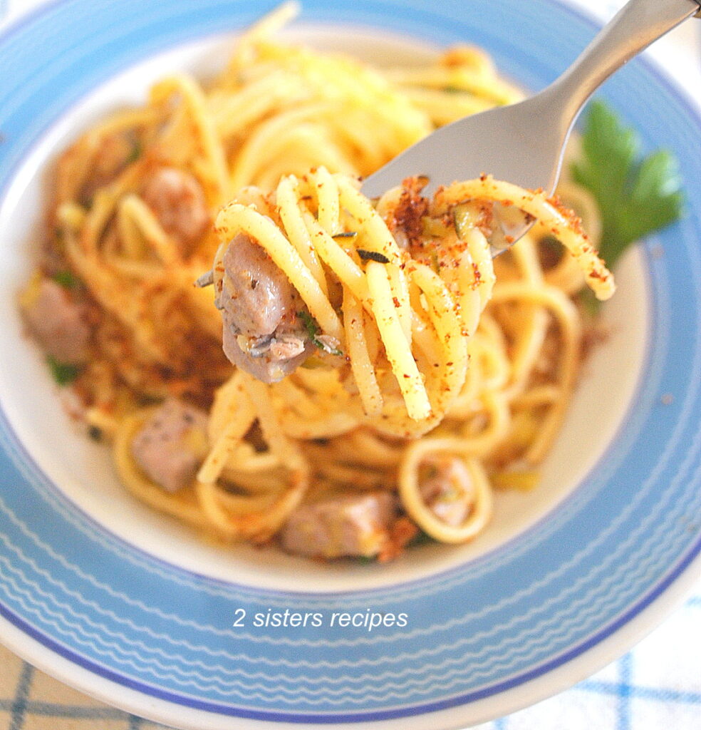 A forkful of spaghetti with toasted bread crumbs and cubed tuna.