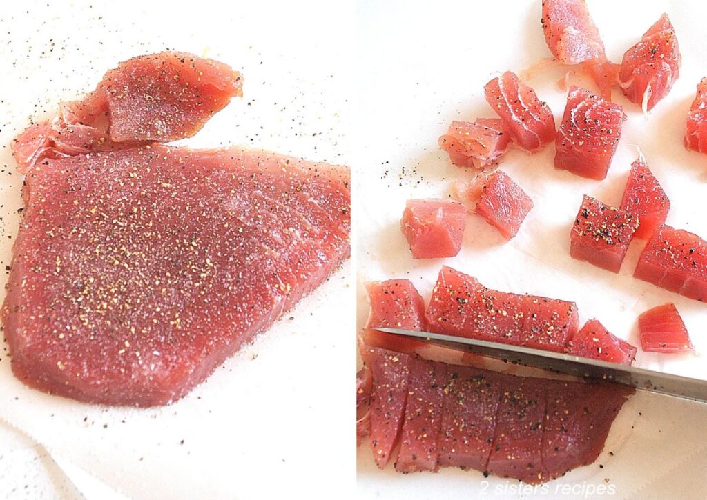 Fresh tuna steak is seasoned with salt and pepper and cut into cubes.