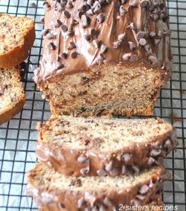 A chocolate covered banana bread on a wire rack, sliced.