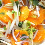 A citrus salad loaded with sliced navel oranges, sliced endives, red onions, and tossed with fresh herbs.