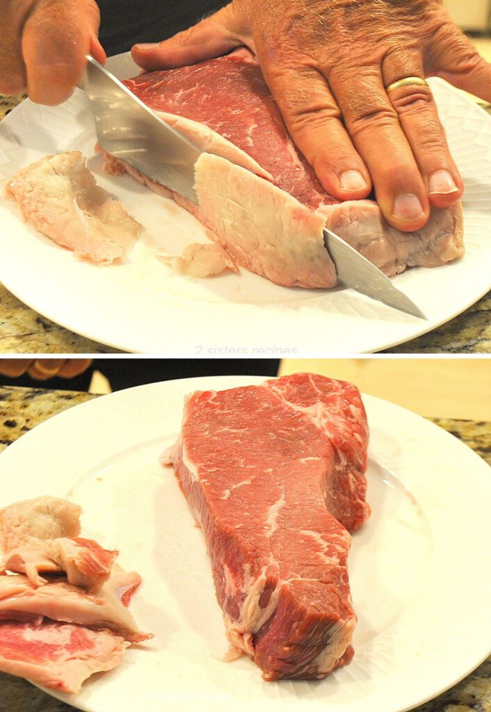 Slicing the fat off the raw New York strip steak on a white dish.