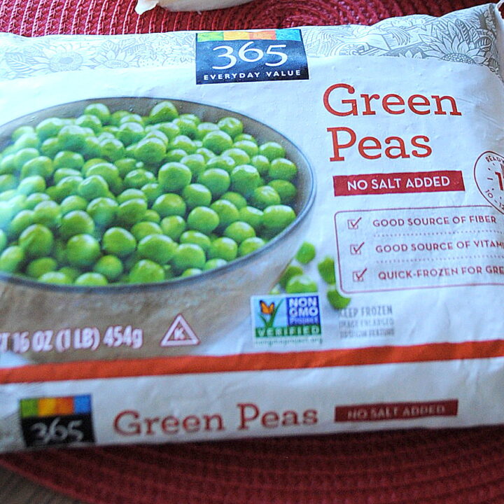 A bag of frozen peas laying on a mat on table.