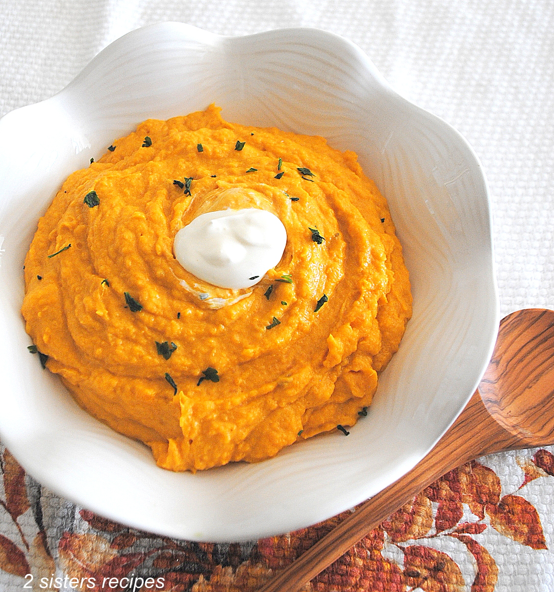 A white bowl filled with mashed pumpkin sweet potatoes.