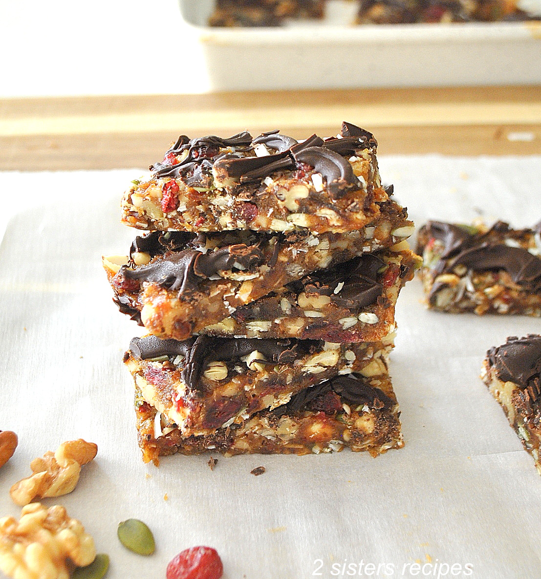 A pile of fruit & nut protein bars on white parchment paper.