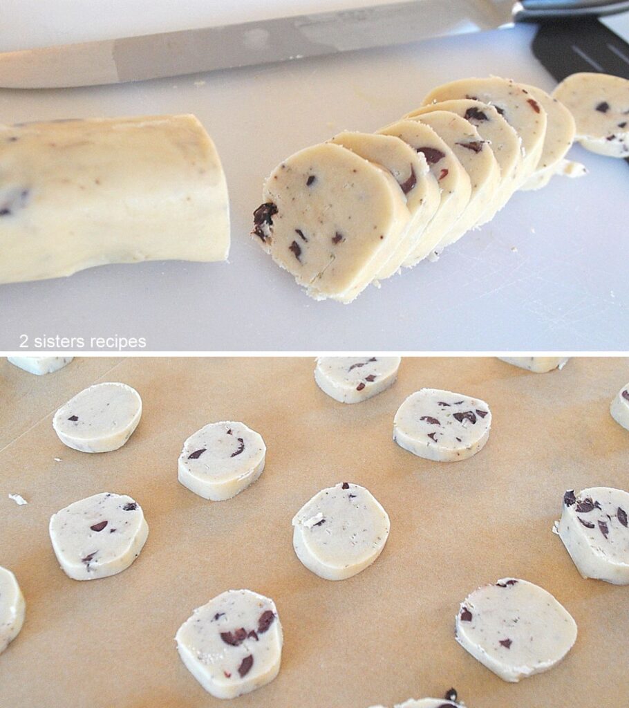 A buttery biscuit dough shaped as a cylinder and sliced into disks and placed onto parchment paper.