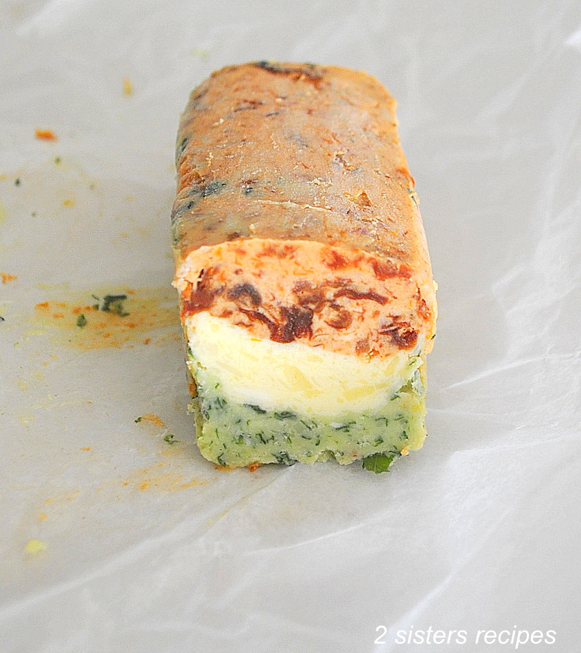 A tri-color stick of butter set on a sheet of wax paper.