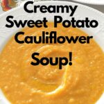 A white bowl filled with creamy sweet potato cauliflower soup.