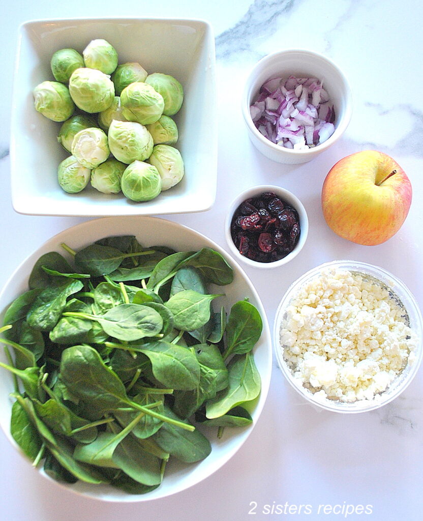 Ingredients for this brussels sprouts salad are placed in white bowls and set on the counter for this salad recipe.